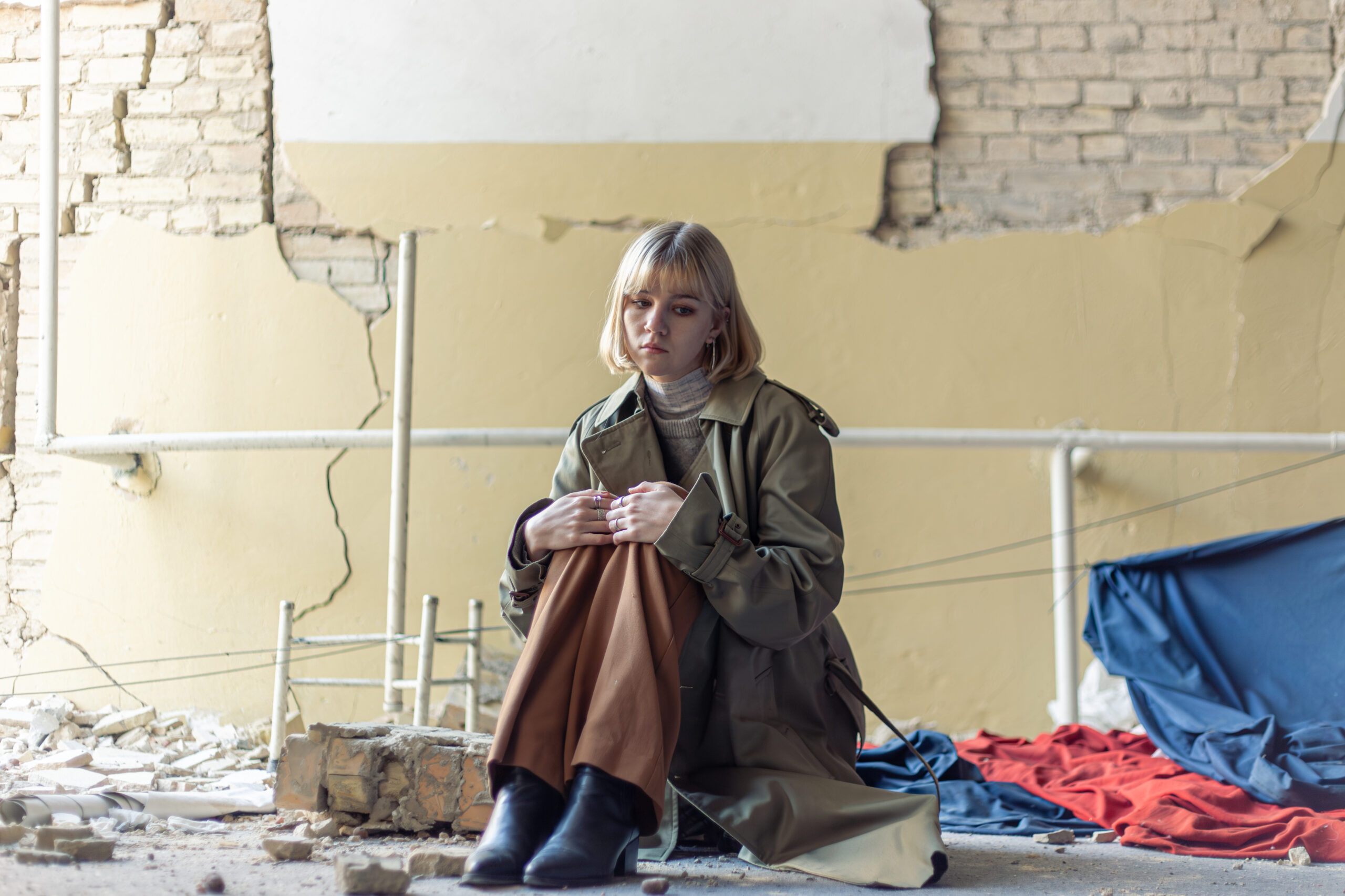 A woman near a house destroyed by the war. War in Ukraine